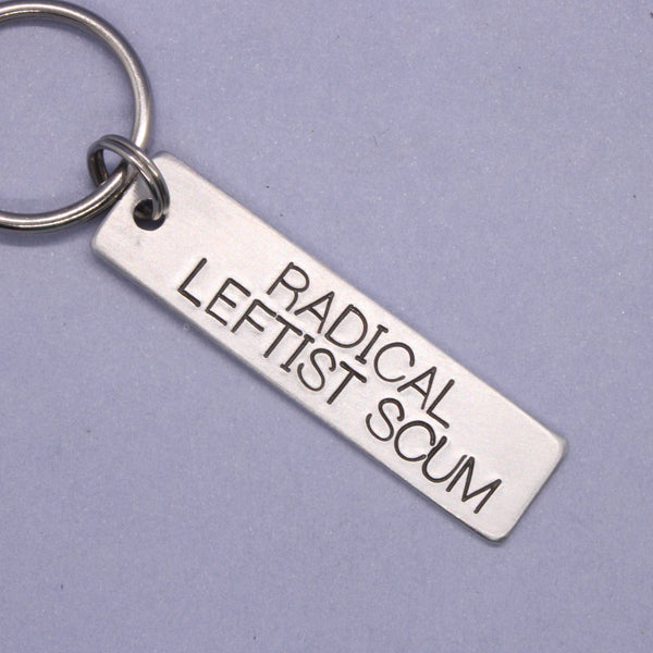 Silver keychain with engraved text on a purple background