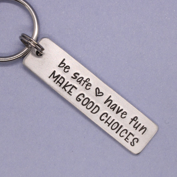 Metal keychain with motivational message on a purple background